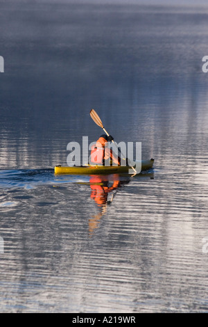 Ein Mann im Morgengrauen durch Berg Reflexionen auf Donner Lake CA Kajak Stockfoto