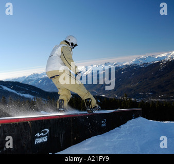 Snowboarder gleiten schnell über eine Schiene in BC. Stockfoto