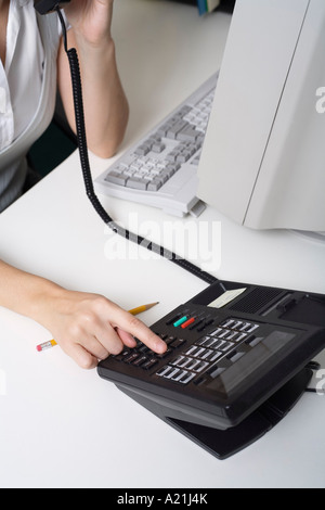 Frauenhand mit Telefon am Schreibtisch Stockfoto