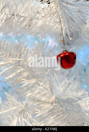 Nahaufnahme Schuss eine einzelne rote Dekoration auf einem weißen Weihnachtsbaum hängen. Stockfoto