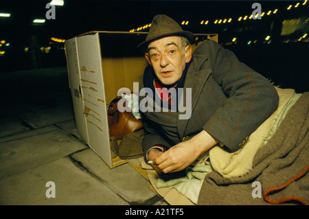 Ein Obdachloser mit einem blauen Auge schlafen rau hinter einem Karton in der Royal Festival Hall, London Stockfoto