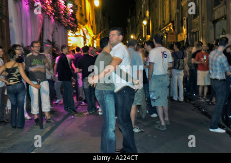 Paris Frankreich, große Menschenmassen, schwules Paar, umarmt auf der Straße im Viertel 'Le Marais' nach 'Gay Pride' in der Stadt bei Nacht, feiert Freiheit Stockfoto