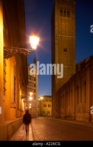 eine einsame Gestalt über Kardinal Ferrari mit dem Campanile Baptisterium in Piazza Duomo über Nacht Parma Emilia Romagna Italien Stockfoto