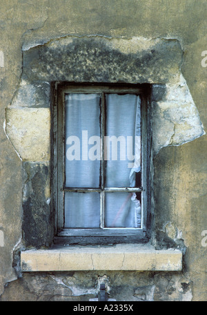 Alte Pariser Gebäudewand und Fenster mit Vorhängen. Heruntergekommenes Steinhaus. Verfallender Putz an der Außenseite eines schlecht gepflegten Hauses. Frankreich Stockfoto