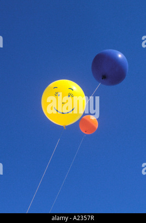 Smiley-Gesichtsballons schweben vor einem blauen Himmel. Central Park New York Happiness. Spielzeug. Sorgenfrei. Stockfoto