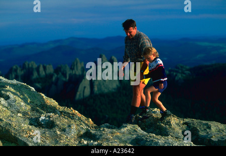 Ein Vater und sein Sohn wandern sorgfältig entlang der Harney Peak hoch in den Black Hills von South Dakota Stockfoto