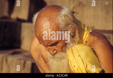 betender Greis in gelb Stockfoto