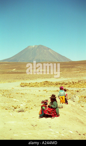 Peruanische Mutter und Kinder sitzen vor El Misti, Arequipa Stockfoto