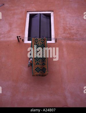 Teppich hängen vom Fenster gegen eine rosa Wand Venedig Italien Stockfoto