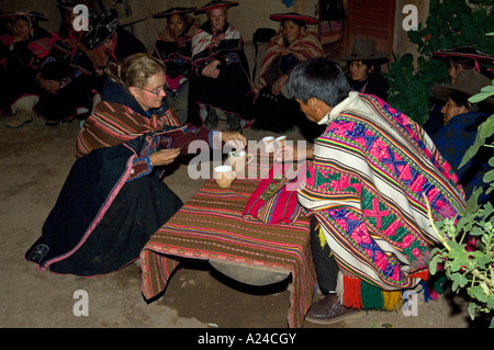 Ein Tourist in peruanischen Tracht gekleidet beteiligt sich an der "Tee-Zeremonie" bei einer lokalen Familie zu Hause. Stockfoto