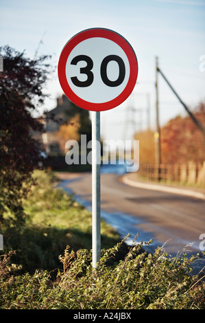 Straßenschild - Geschwindigkeitsbegrenzung 30 km/h auf einer Landstraße am Rande eines kleinen Dorfes, England, Großbritannien Stockfoto