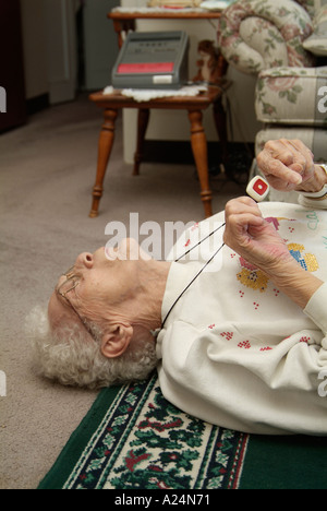 Senioren weiblich verwendet eine medizinische Alarm Alarmanlage für Notruf für Hilfe nach einem Sturz Stockfoto