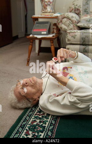 Ältere Frauen verwenden ein medizinisches Alarmsystem für Notrufe nach einem Sturz bei einem Unfall Stockfoto