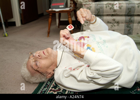 Senioren weiblich verwendet eine medizinische Alarm Alarmanlage für Notruf für Hilfe nach einem Sturz Stockfoto