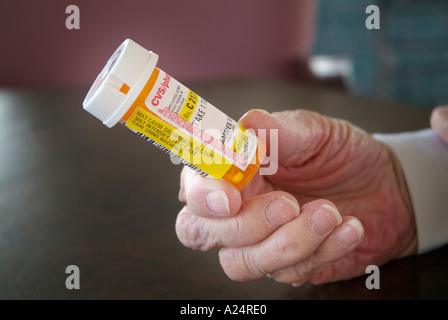 85 Jahre alten Senior nimmt verschreibungspflichtiges Medikament um schlafen zu unterstützen Stockfoto