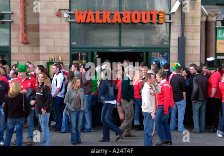 Rugby-Fans außerhalb WALKABOUT INN Schlange um in Pubs und Bars in Cardiff am Tag von einem Wales internationale bekommen entsprechen Stockfoto