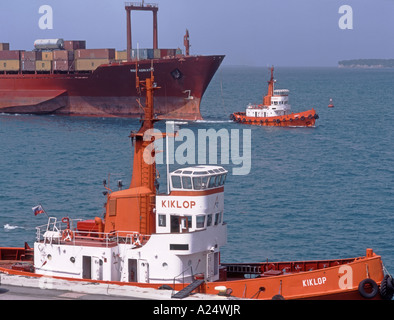 Koper, Slowenien Primorska. Schlepper ziehen große Containerschiff im Hafen von Koper Stockfoto