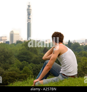 Junger Mann sitzt in Primrose Hill London Skyline kein Model Release Winkel, Rückansicht und Ernte macht ihn unkenntlich Stockfoto