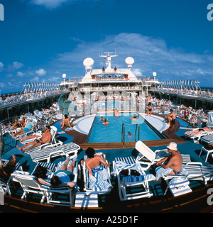 PASSAGIERE AUF SONNENLIEGEN ENTSPANNEN AN DECK DES LUXUS-KREUZFAHRT Stockfoto