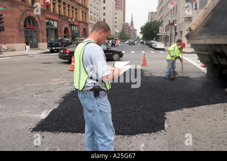 Junger Mann, die Überwachung der Reparaturarbeiten Straße Stockfoto