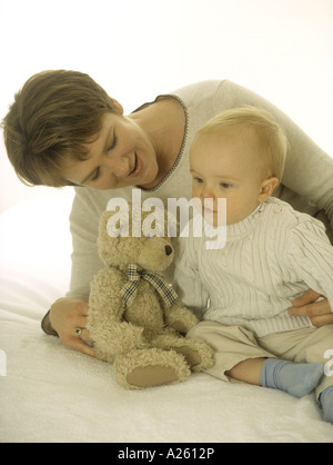 Porträt einer Mutter mit ihrem Baby einen Teddybär gemeinsam betrachten Stockfoto