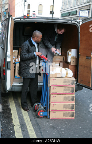 Leute, die entladen boxed von Transit liefern van Stockfoto