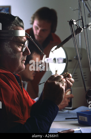 Ein mittleren Alters Techniker Modelle sorgfältig eine zahnärztliche Prothetik in einem Produktionslabor beschäftigt. Stockfoto