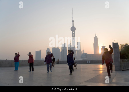 Menschen üben Tai Chi auf den Bund, vor der Skyline von Shanghai, China Stockfoto