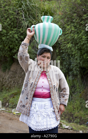 GUATEMALA CAPELLANIA Young indigene Maya-Quiche-Frau in traditioneller Kleidung und Schürze trägt Wasser in einen Krug auf dem Kopf Stockfoto