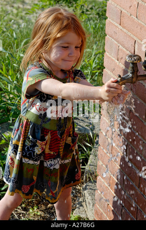 MT Mädchen spielt mit Wasser im Sommer Stockfoto