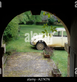 einen alten Citroen 2CV in einem französischen Garten gesehen durch ein Steinbogen Stockfoto