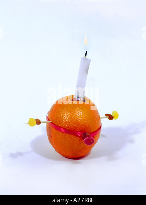 Christingle Orange symbolisiert die Welt, Kerze Jesus Christus das Licht der Welt, rotes Band das Blut Christi und die vier Süßigkeiten die vier Ecken Stockfoto