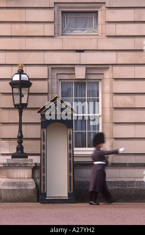 Fuß Königinnenwache schreiten verschwommen Bewegung neben Guardbox auf Vorderseite des Buckingham Palace, London, England Stockfoto