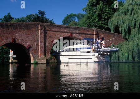 Eine große Motoryacht durch den Bogen des Sonning-Brücke über die Themse, Sonning, Berkshire, England manövrieren Stockfoto