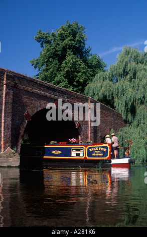 Paar Lenkung traditionellen Narrowboat unter Sonning-Brücke über die Themse, Sonning, Berkshire, England Stockfoto