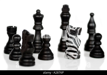 Einzelne Zebra gehäutet Ritter Schachfigur in einer Gruppe von schwarzen Figuren als Symbol für eine Reihe von Konzepten, die unter anderem als stehend Stockfoto