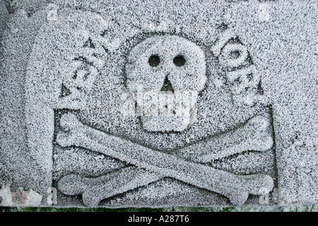 Schädel und gekreuzten Knochen Design auf Grabstein in Frost bedeckt Stockfoto