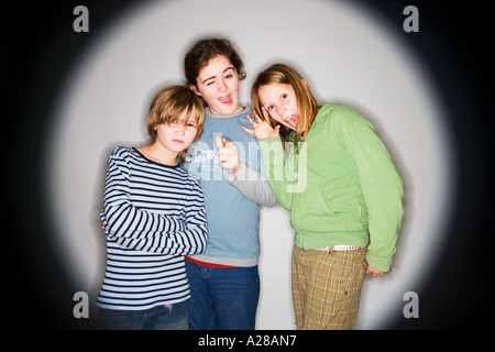 ZWEI JUNGS UND EIN MÄDCHEN, GRIMASSIEREN Stockfoto