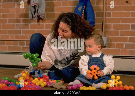 Arbeitnehmerin spielt mit Kleinkind in einer non-Profit-private Kindertagesstätte für Kinder in Providence, Rhode Island Stockfoto