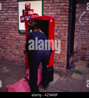 Postbote Briefkasten entleeren Stockfoto