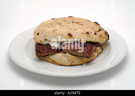 Ćevapčići traditionelle bosnische Gerichte hergestellt aus 50 % gehackter Lamm und 50 % gehackte Rindfleisch serviert In ein Brot Farl mit frisch geschnittene Zwiebel Stockfoto