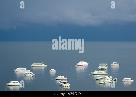 Der Hafen von Copacabana in den frühen Morgenstunden mit dunklen grauen Regenwolken und flach ruhiger See. Stockfoto