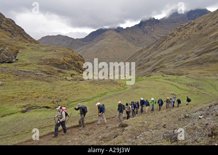 Eine Gruppe von Touristen und Guides trekking durch die zerklüftete Landschaft der Anden auf der "Gemeinschaft" Inka-Trail. Stockfoto