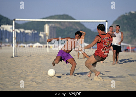 Männer spielen Fußball auf dem Sand am Strand der Copacabana in Rio De Janeiro Brasilien Stockfoto