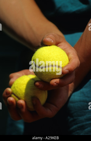 Nahaufnahme von ein paar Hände halten zwei gelbe Tennisbälle Stockfoto