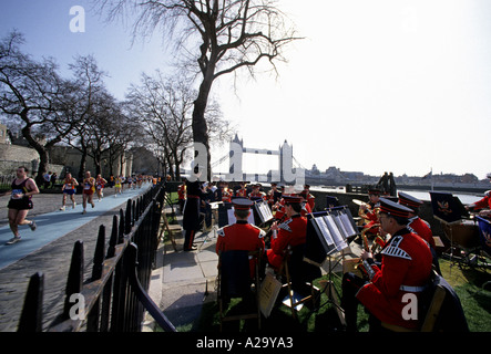 Läufer in den London-Marathon kommen vorbei an der Tower of London spielt die Band neben der Themse Stockfoto