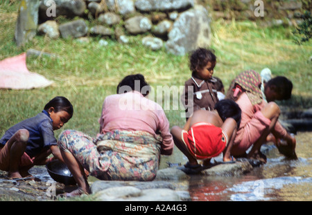 Frauen Kinder waschen Kleidung Pashupatinath Bagmati Fluss Nebenfluss Ganges Kathmandu Nepal Anbeter Stockfoto