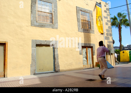 Mann zu Fuß vorbei an hell gefärbt gelb bemalten Gebäude in Las Palmas de Gran Canaria, Gran Canaria, Kanarische Inseln Stockfoto