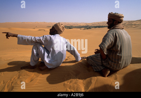 Zwei Männer in traditionellen Kleidern sitzen auf einer Düne, Libyen Stockfoto