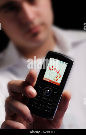 Junger Mann mit Royal Flush auf Handy Stockfoto